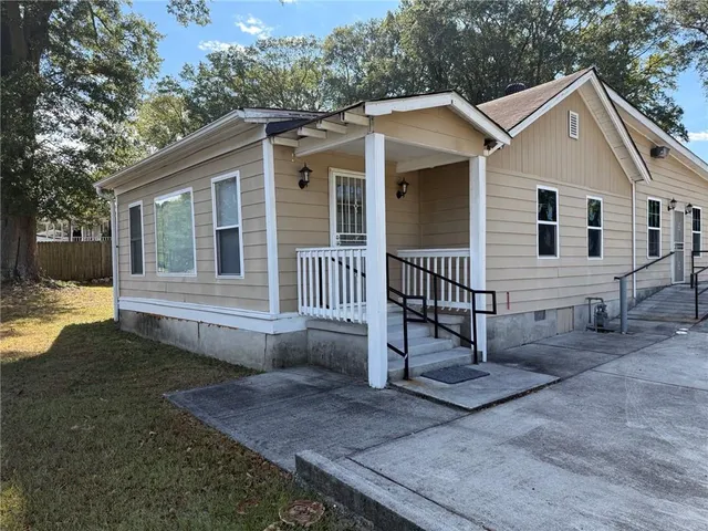 a view of a house with a yard and wooden fence
