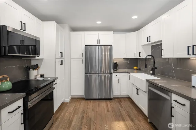 a kitchen with stainless steel appliances granite countertop a refrigerator sink and stove