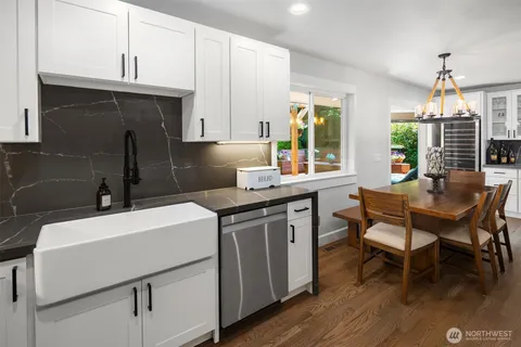 a kitchen that has a sink a table and chairs in it