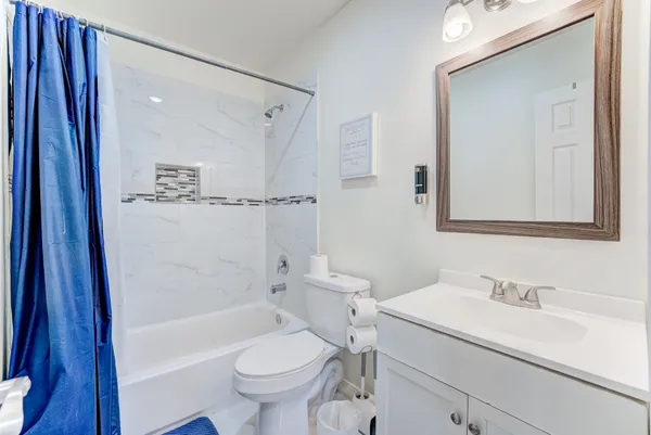 a bathroom with a bathtub shower sink vanity and toilet