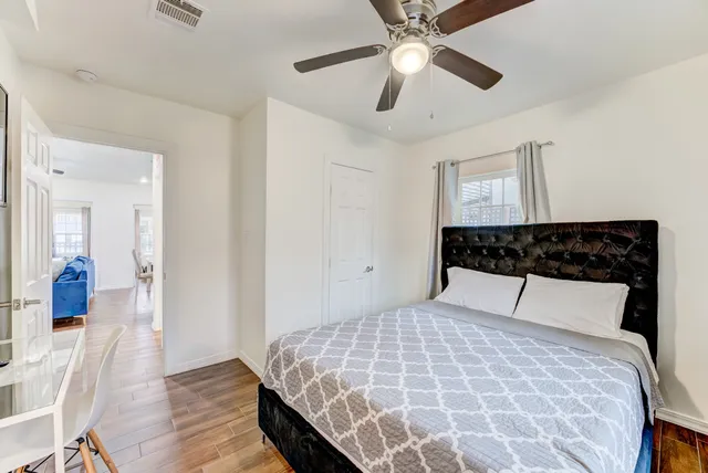 a bedroom with a large bed and a chandelier