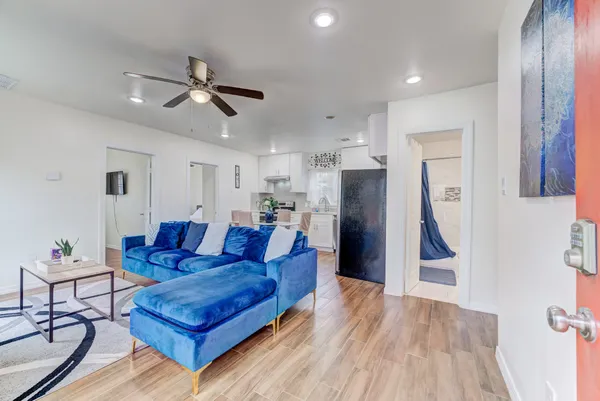 a living room with furniture and a wooden floor