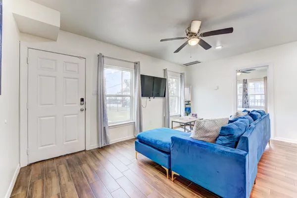 a kitchen with stainless steel appliances a stove a sink a refrigerator white cabinets and wooden floor