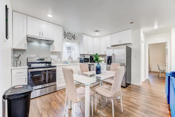 a living room with furniture a flat screen tv and wooden floor
