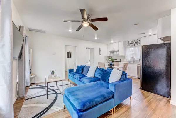 a kitchen with stainless steel appliances a white table chairs and a refrigerator