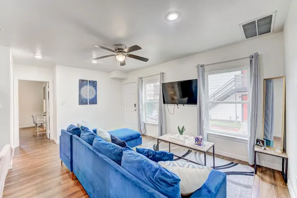 a kitchen with cabinets stainless steel appliances and wooden floor