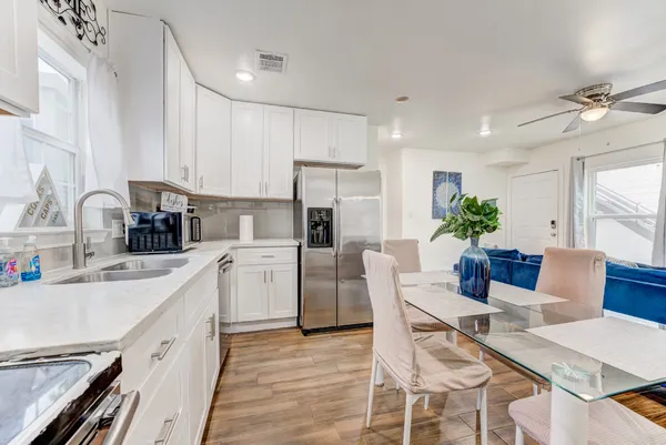 a kitchen with stainless steel appliances granite countertop a stove a sink and white cabinets