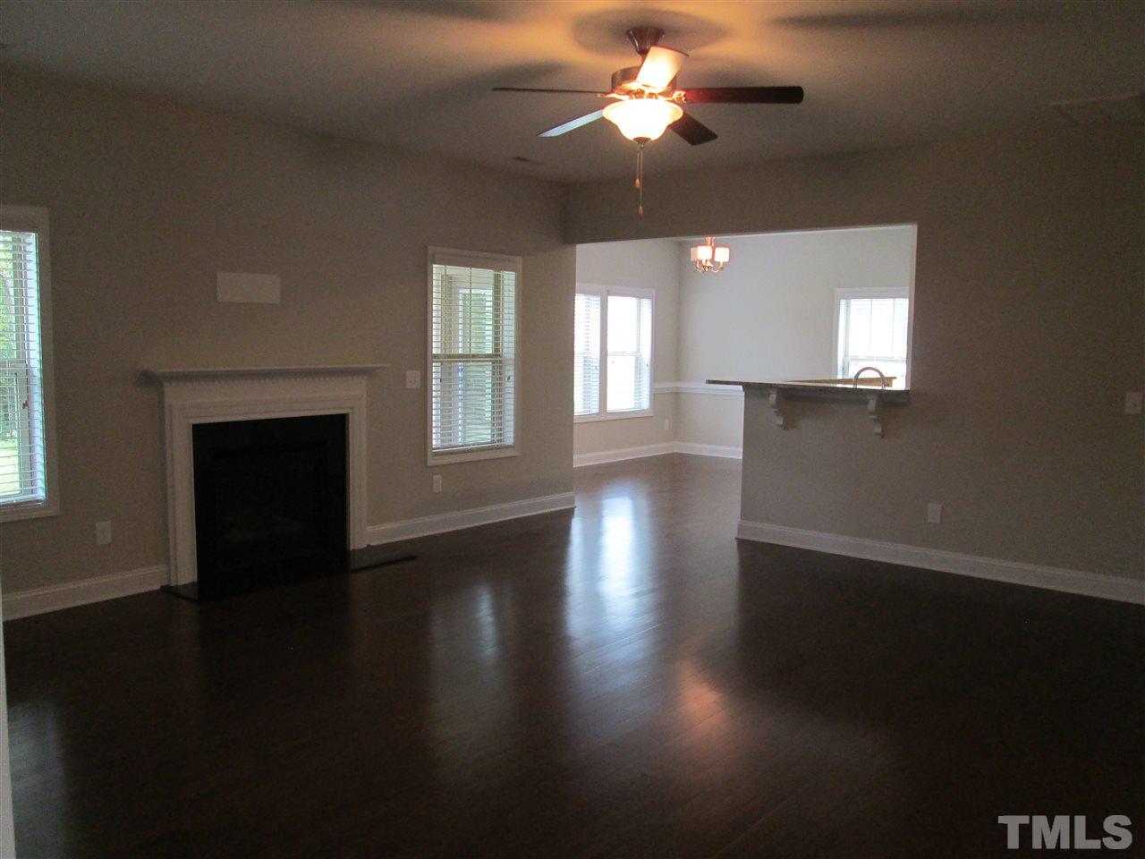 3438 Grosbeak Way Raleigh, NC 27616 - Photo 4 of 19 a view of an empty room with wooden floor and a window
