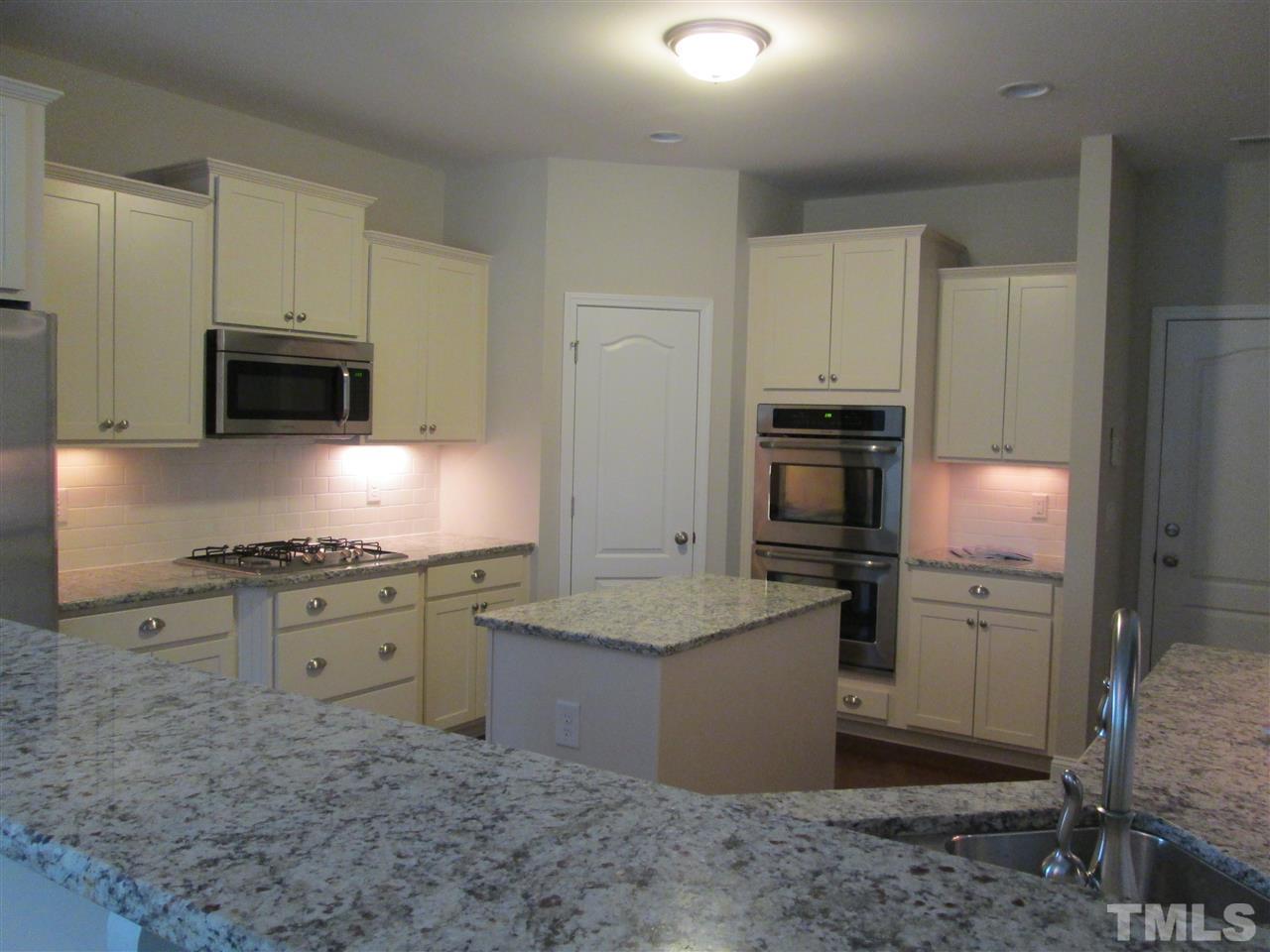 3438 Grosbeak Way Raleigh, NC 27616 - Photo 6 of 19 a kitchen with stainless steel appliances granite countertop a stove a sink and a refrigerator