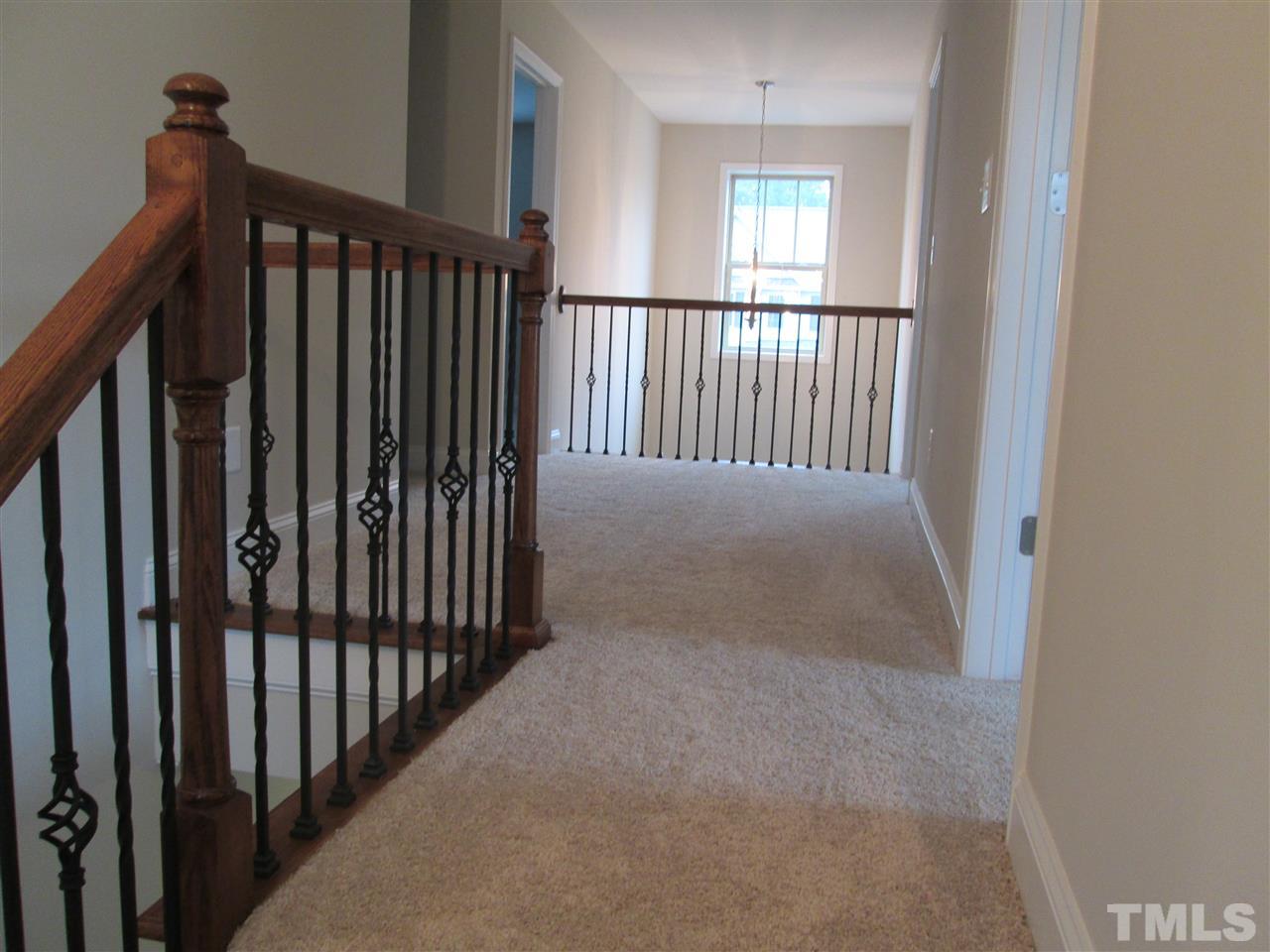 3438 Grosbeak Way Raleigh, NC 27616 - Photo 8 of 19 a view of a hallway with wooden floor and stairs