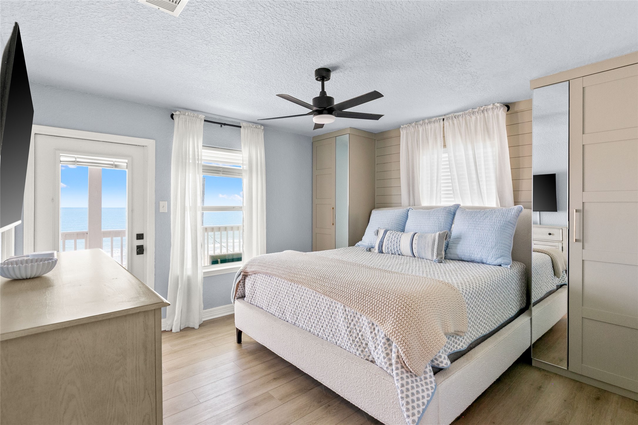 1213 Sargasso Circle Surfside Beach, TX 77541 - Photo 14 of 40 a bedroom with a large bed a chandelier and windows