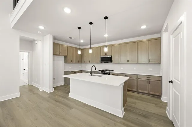 a view of a kitchen with a sink and refrigerator