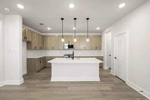 a kitchen with white cabinets and appliances