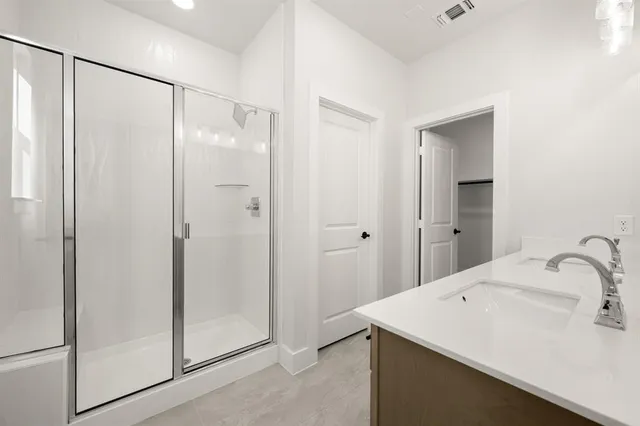 a bathroom with a double vanity sink a mirror and a shower