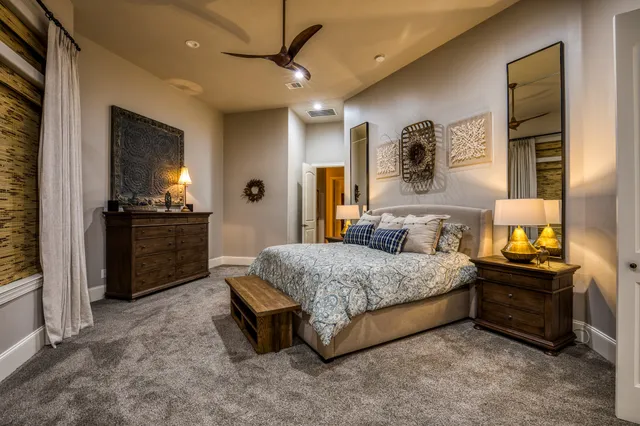 a spacious bedroom with a bed and a chandelier
