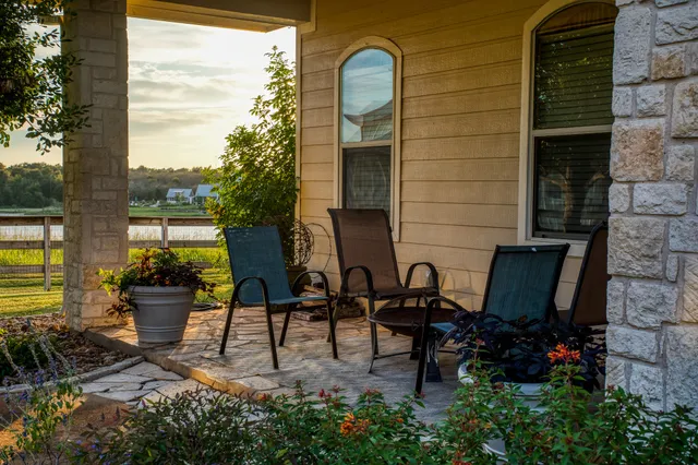 a view of a chairs with potted plants in front of house