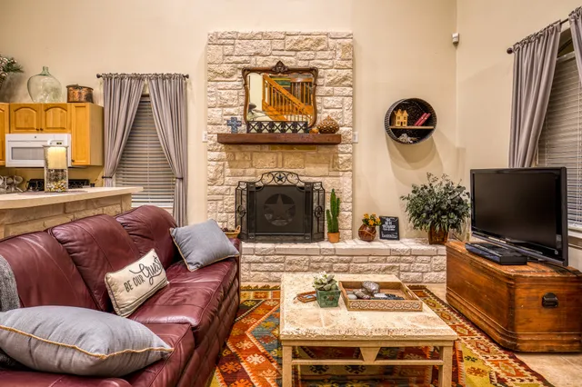 a living room with furniture a flat screen tv and a fireplace