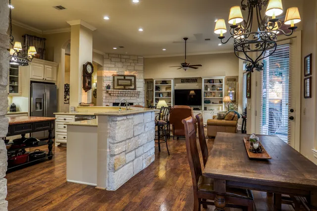 a kitchen with a table chairs refrigerator and cabinets