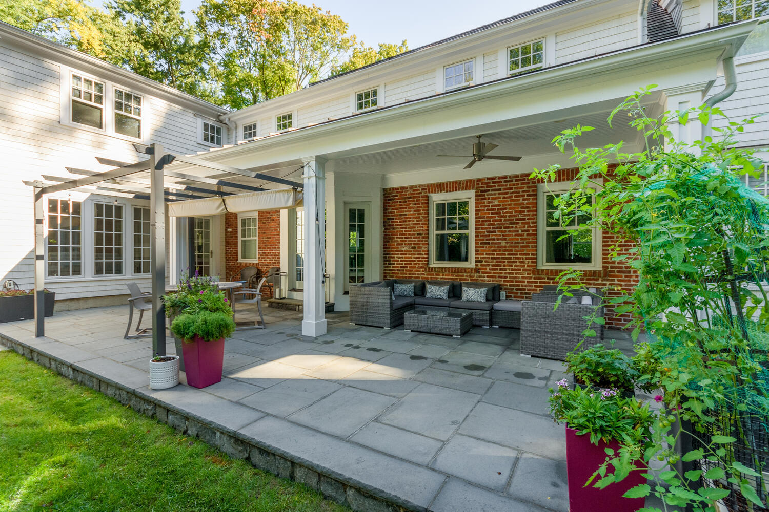 293 Hollow Tree Ridge Road Darien, CT 06820 - Photo 41 of 46 a front view of a house with outdoor seating and a garden