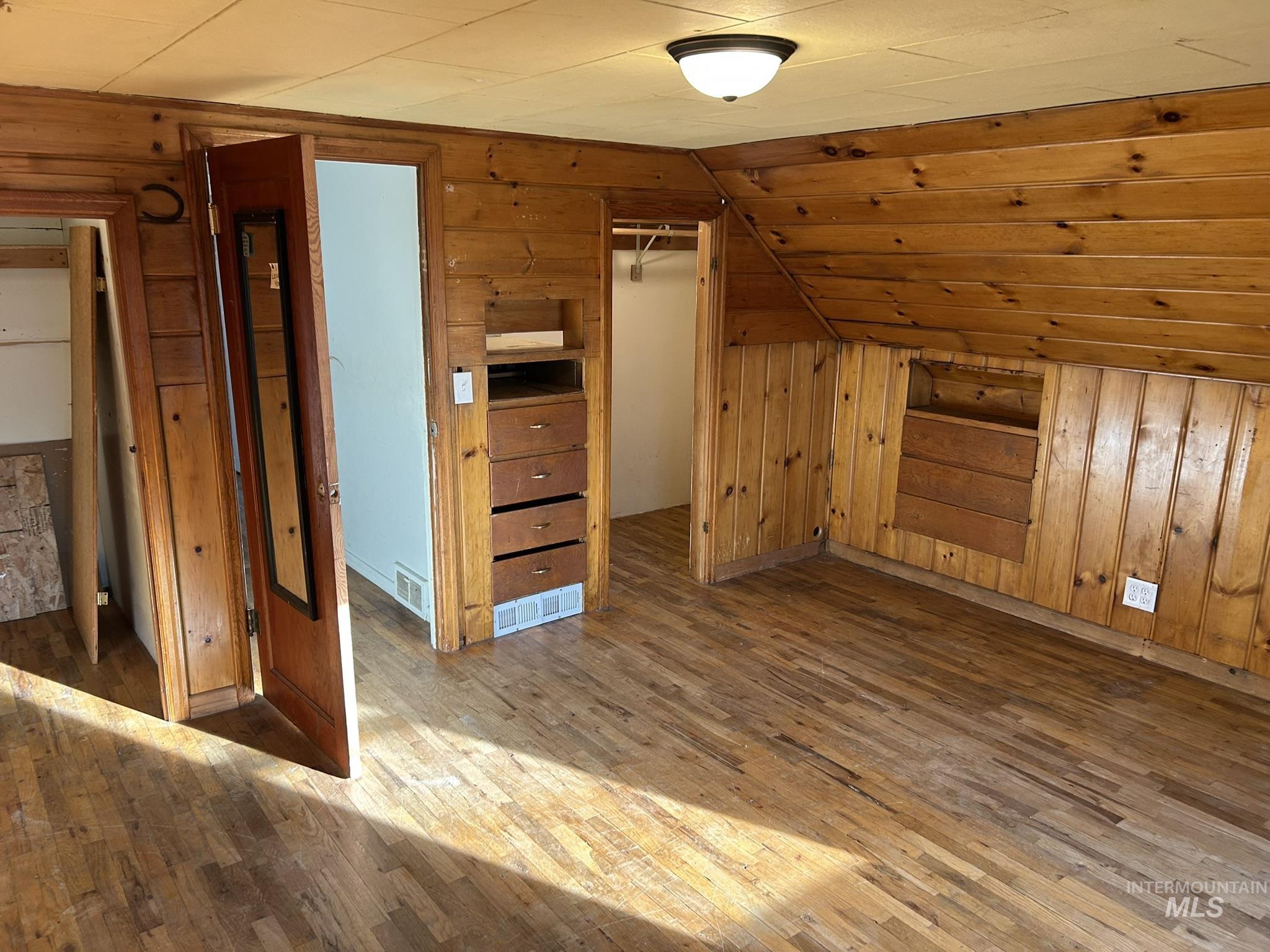 3837 16th Street Lewiston, ID 83501 - Photo 33 of 45 Additional living space with wooden walls, hardwood / wood-style floors, and vaulted ceiling