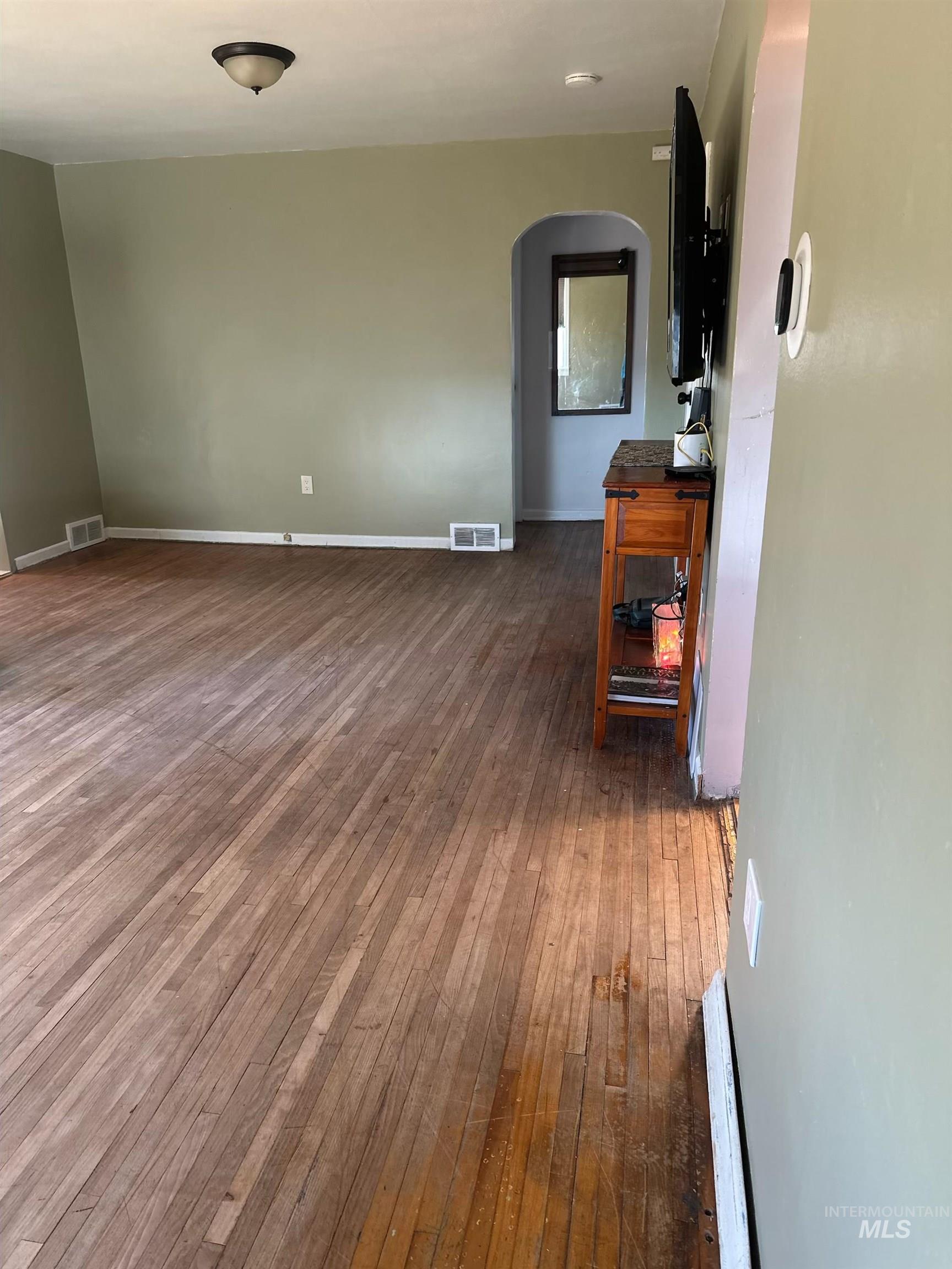 3837 16th Street Lewiston, ID 83501 - Photo 6 of 45 Unfurnished room with arched walkways and dark wood-type flooring