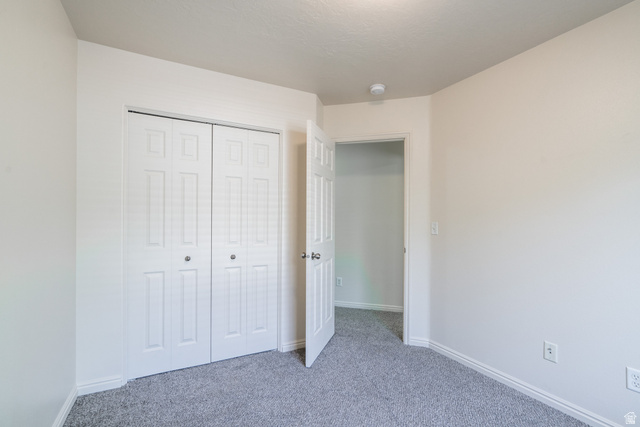 1735 West 540 North, Unit 1805 St. George, UT 84770 - Photo 61 of 64 Neutral wall paint with textured ceiling, gray carpet flooring, white baseboards, and white bi-fold closet doors