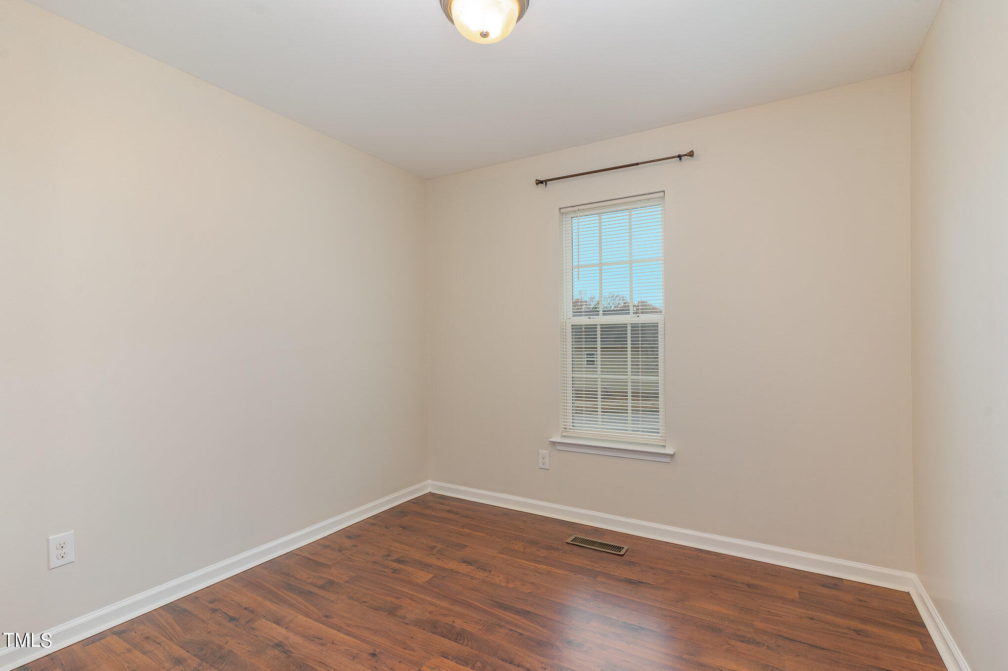 607 2nd Street Apex, NC 27502 - Photo 11 of 16 a view of an empty room with wooden floor and a window