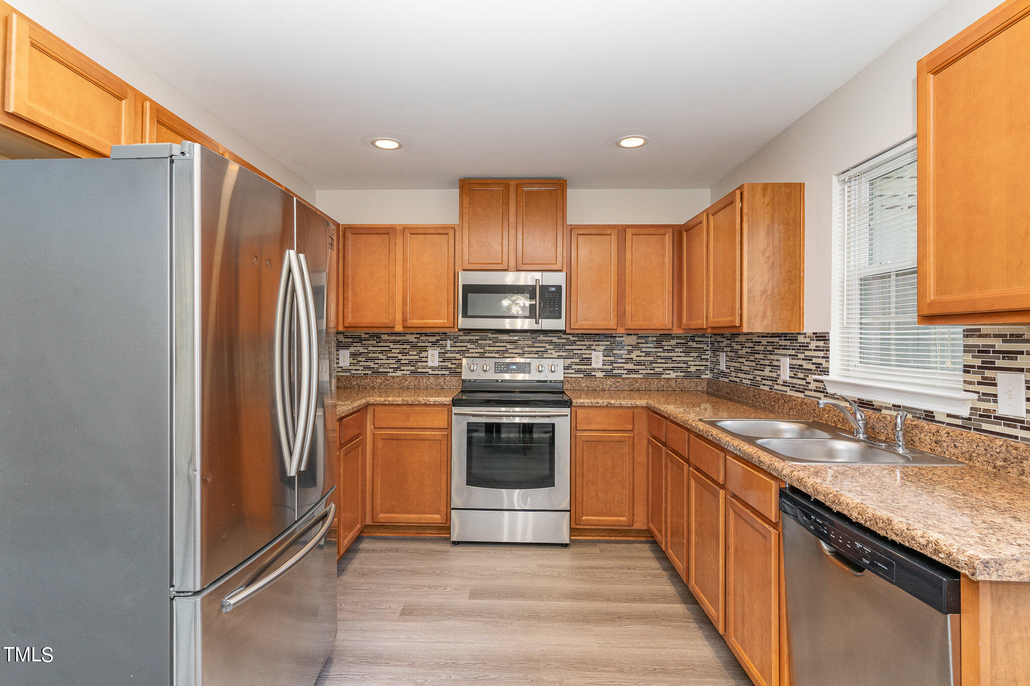 607 2nd Street Apex, NC 27502 - Photo 7 of 16 a kitchen with granite countertop stainless steel appliances a sink cabinets and a window