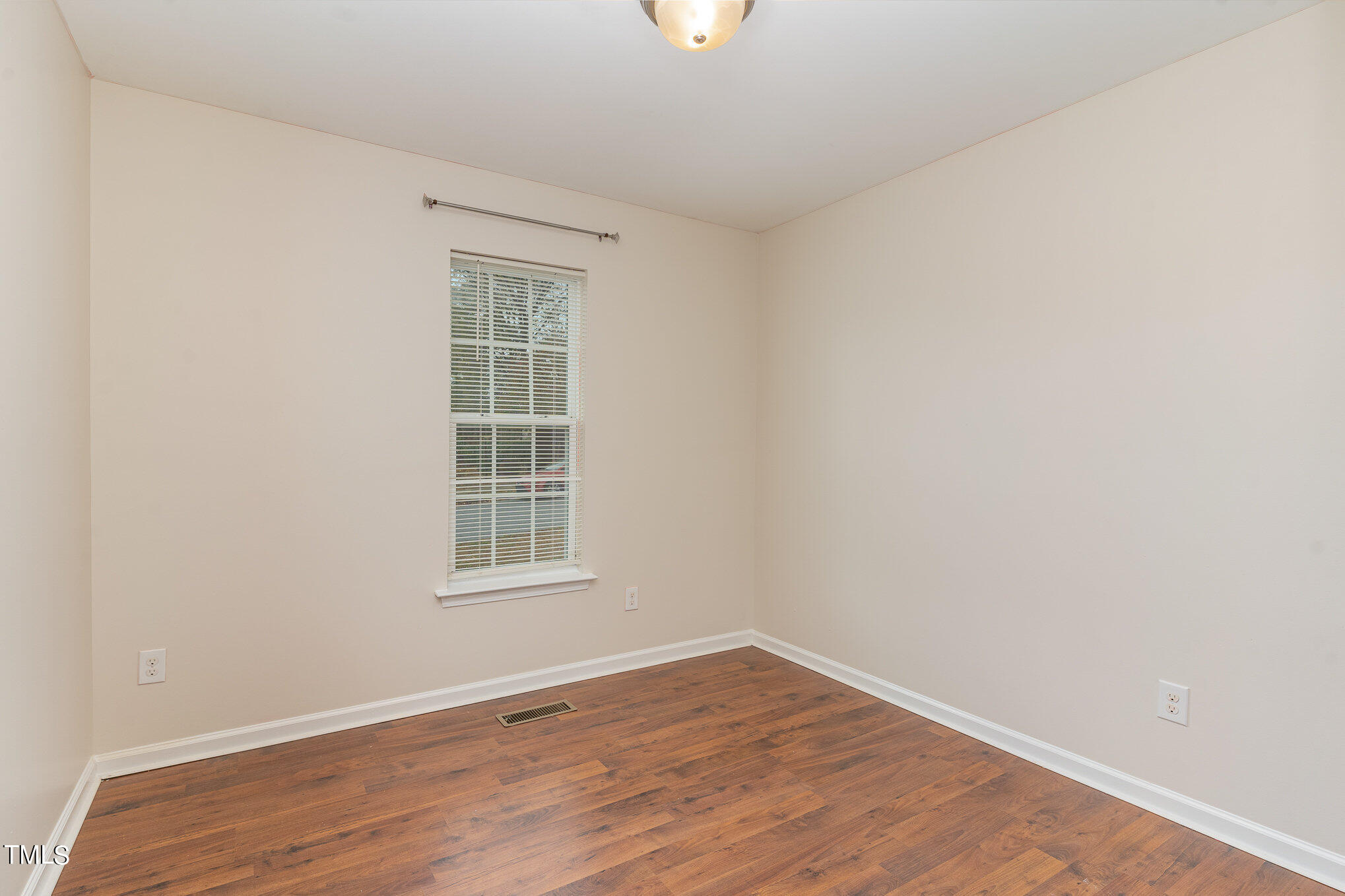 607 2nd Street Apex, NC 27502 - Photo 9 of 16 a view of an empty room with wooden floor and a window