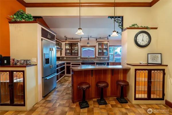 a view of a kitchen with stainless steel appliances granite countertop a stove and a table