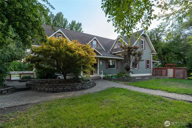 a front view of a house with a garden and trees