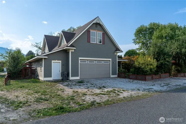 a front view of house with yard and trees in the background