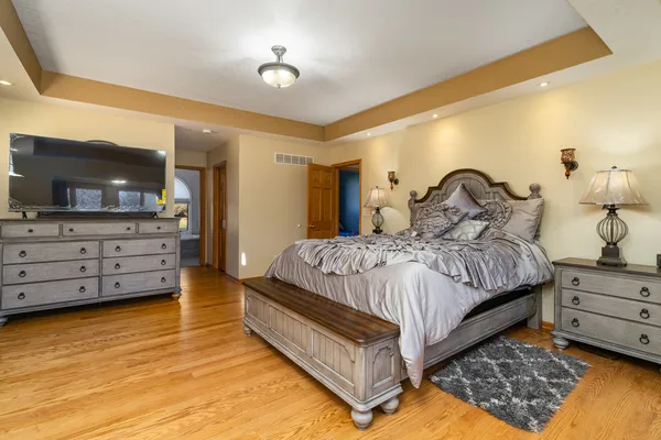 a bedroom with a bed and a flat tv screen on wall