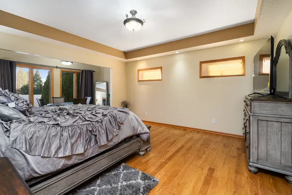 a bedroom with a bed and a lamp on dresser