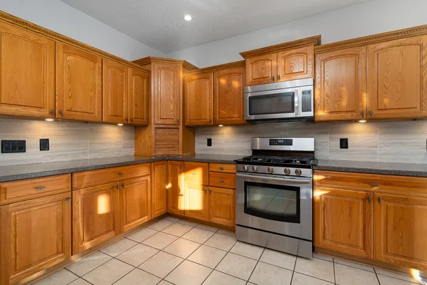 a kitchen with stainless steel appliances granite countertop a sink a stove and a refrigerator