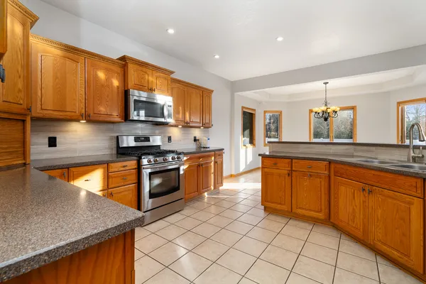 a kitchen with stainless steel appliances granite countertop a refrigerator and a sink