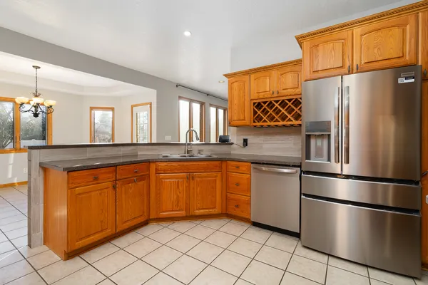 a kitchen with stainless steel appliances granite countertop a refrigerator a stove top oven and a sink with granite countertops