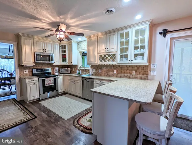 a kitchen with a stove a sink a dining table and chairs