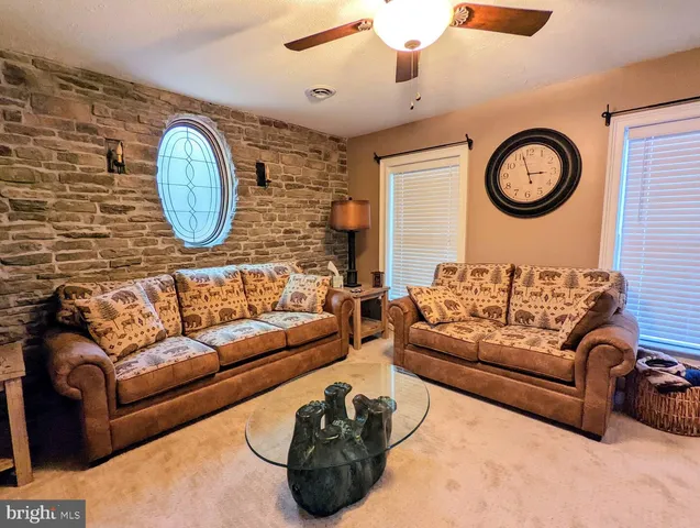 a living room with furniture a clock and a mirror