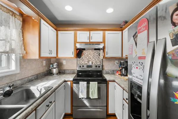a kitchen with stainless steel appliances a stove a sink and a refrigerator