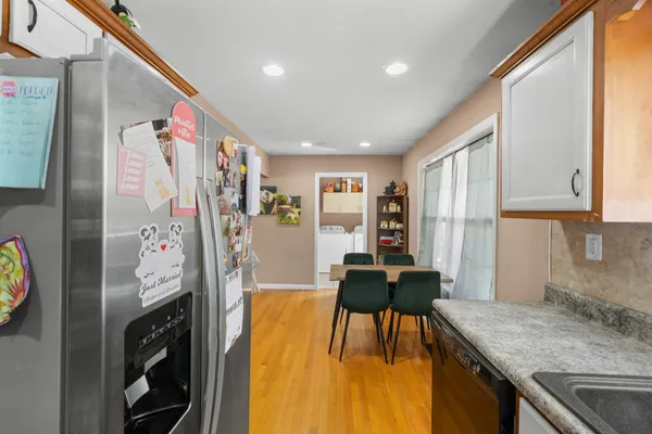 a dining room with stainless steel appliances granite countertop furniture and a kitchen view
