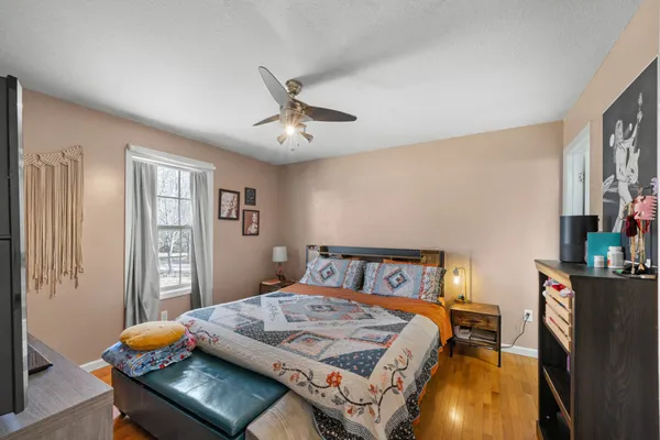 a bedroom with a bed and wooden floor
