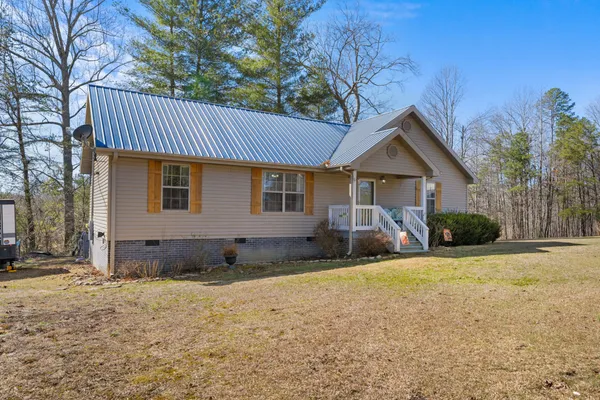 a front view of a house with yard and trees