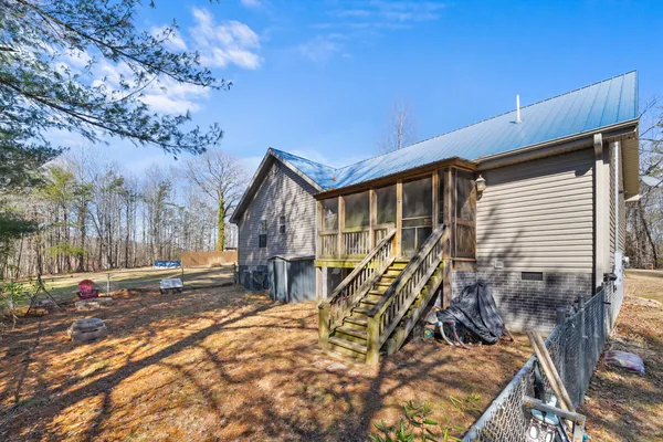 a view of backyard of house with wooden deck and seating space