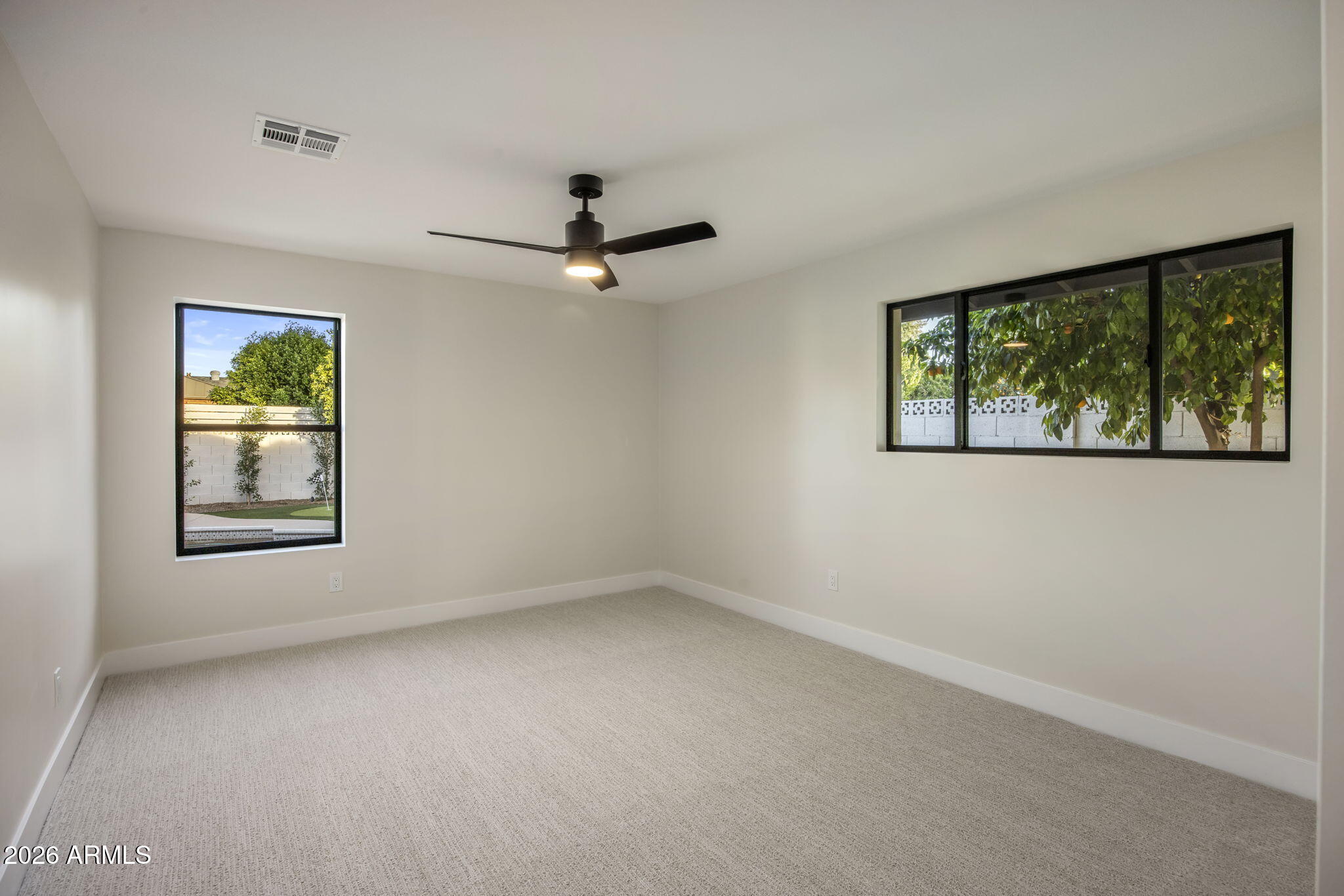 3023 North 49th Street Phoenix, AZ 85018 - Photo 20 of 32 an empty room with windows and ceiling fan