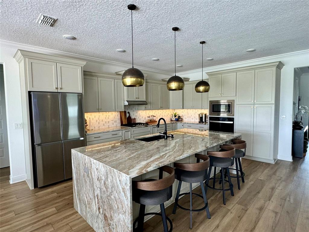 9232 Southwest 85th Place Ocala, FL 34481 - Photo 11 of 38 a kitchen with stainless steel appliances granite countertop a kitchen island a table and chairs in it