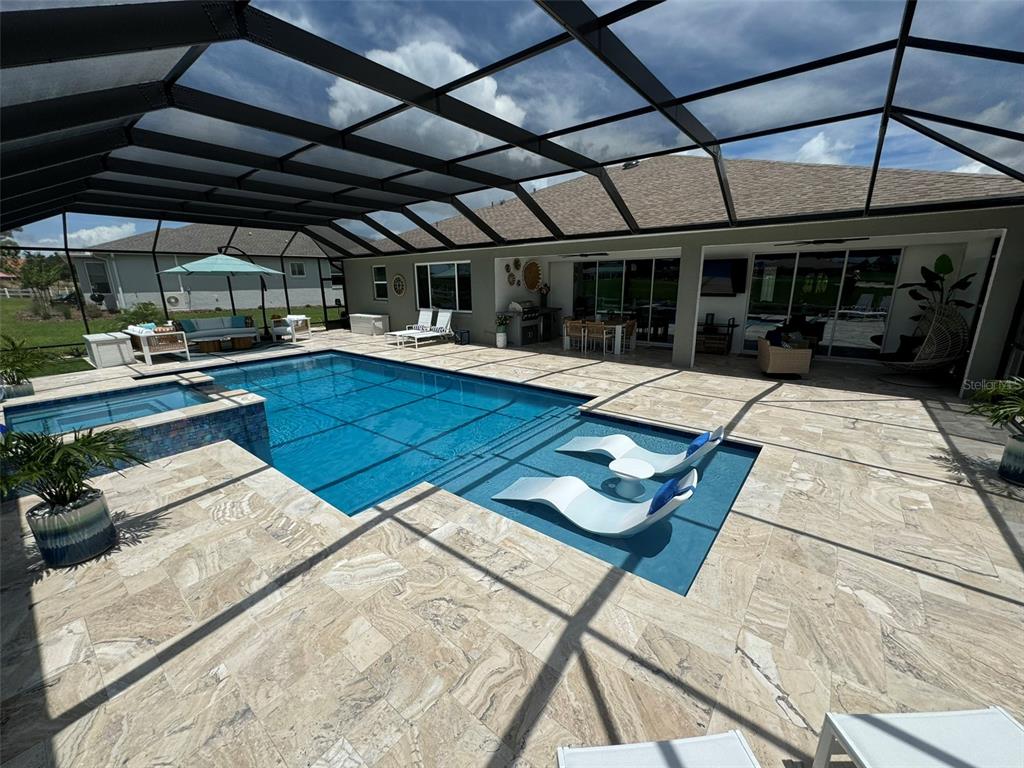 9232 Southwest 85th Place Ocala, FL 34481 - Photo 27 of 38 a view of a patio with table and chairs under an umbrella with a barbeque