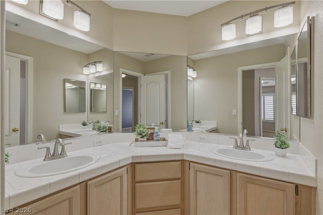 29 Olive Tree Henderson, NV 89074 - Photo 38 of 60 This bright bathroom features a spacious dual vanity with ample storage and modern lighting.