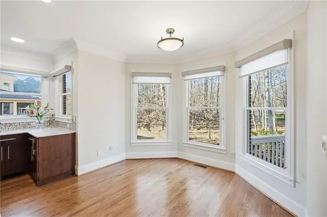 a view of a hallway with wooden floor and windows