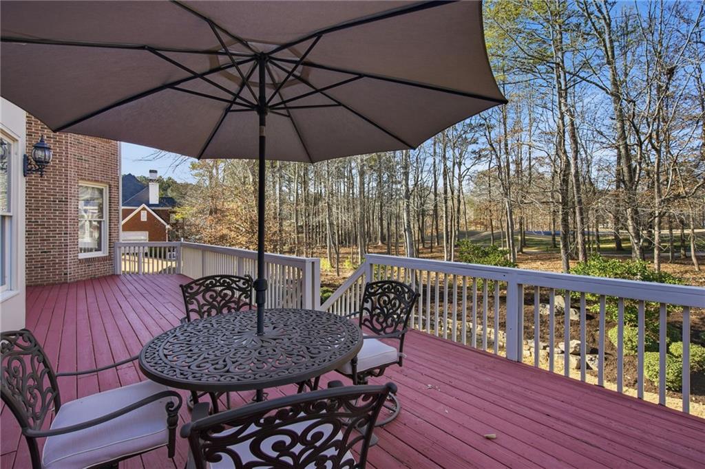 715 Crown Cove Milton, GA 30004 - Photo 25 of 102 a patio with wooden floor a yard a table and chairs